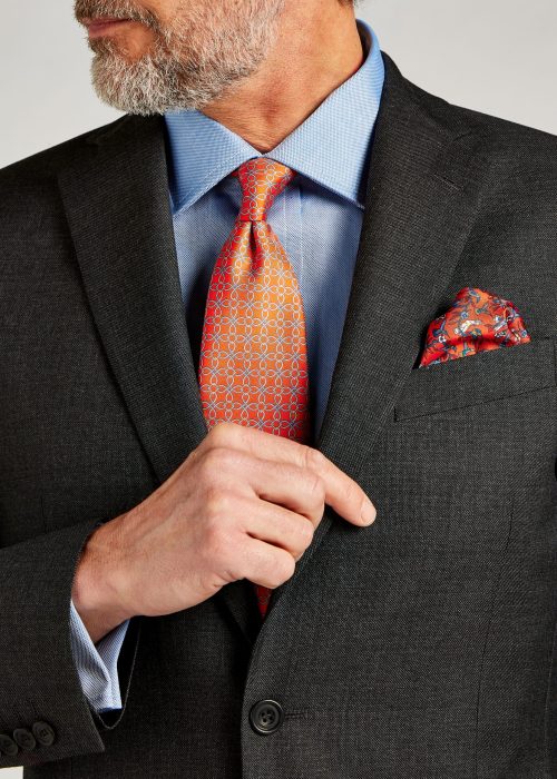 Roderick Charles mid grey pic and pic suit styled with blue shirt and orange tie