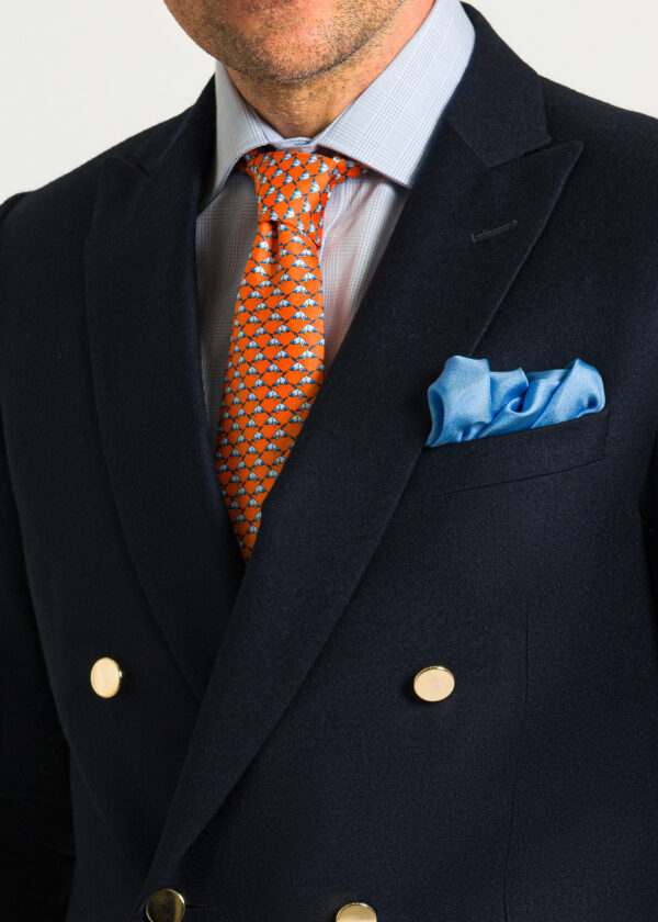 Style a double breasted navy flannel blazer with tonal sky blue pocket square and contrasting tie.