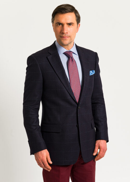 A stunning navy jacket with grey overcheck, styled formally with red tie and blue pocket square.