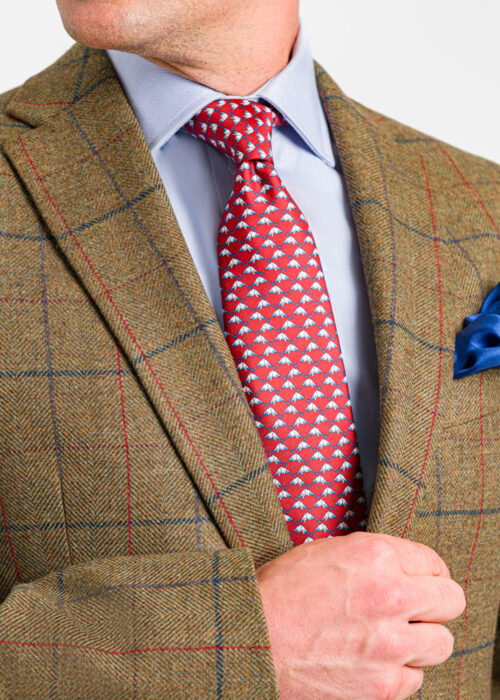 A stylish Roderick Charles green jacket with a red and navy check styled with a blue silk pocket square